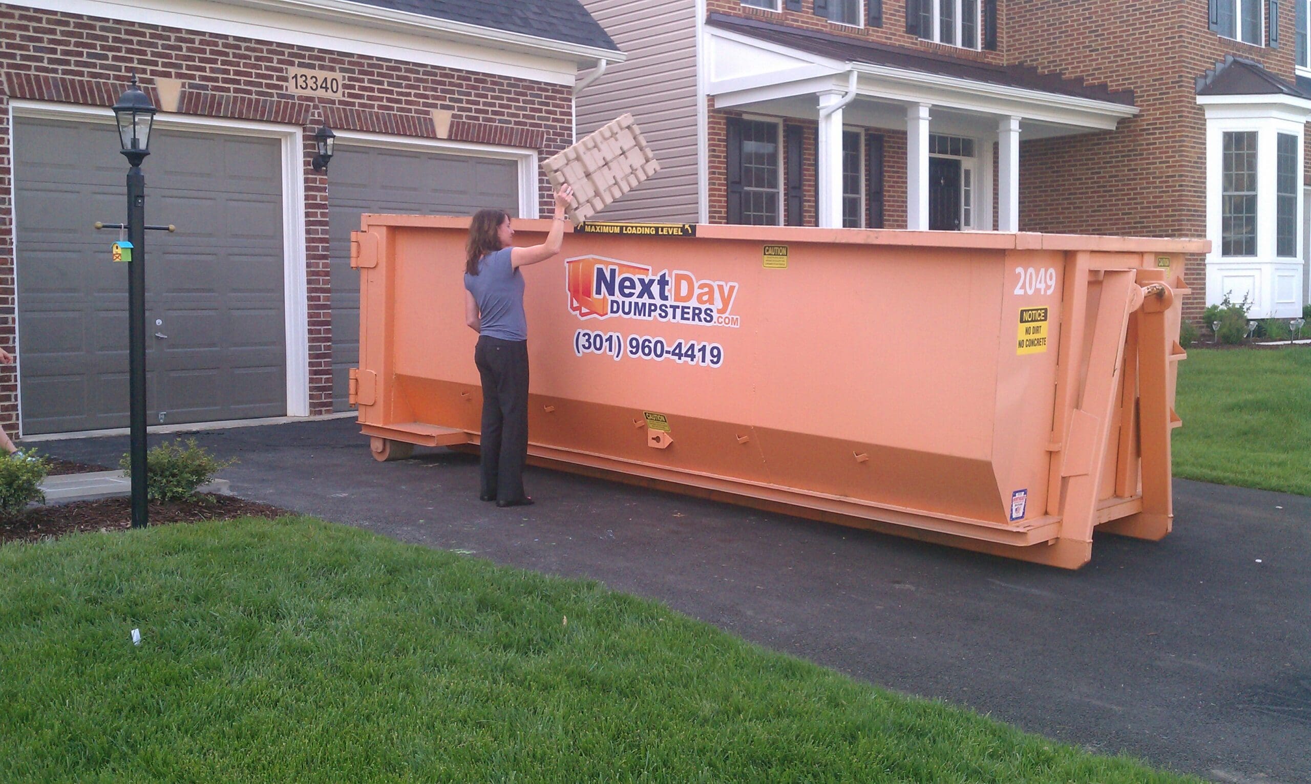 dumpster in driveway with woman