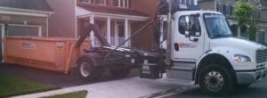 Truck dropping off roll off dumpster