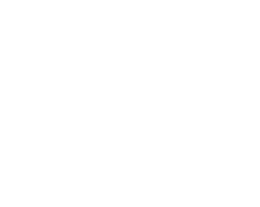 Industrial factory with a row of windows and a tall smokestack.