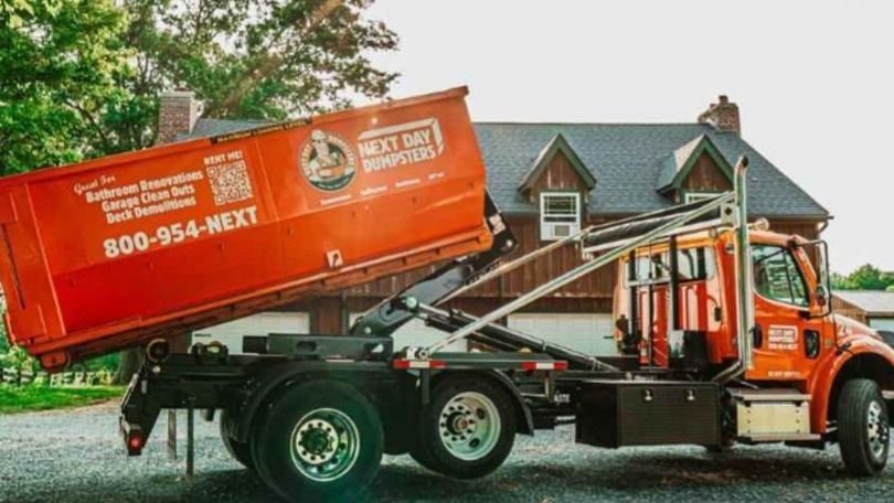 Truck dropping off a roll-off dumpster